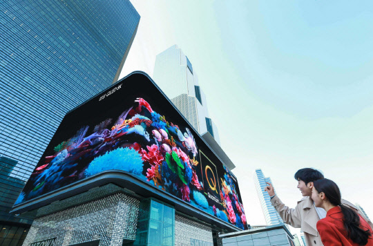 삼성전자가 2019년형 'QLED 8K' TV 출시를 기념해 지난 25일부터 코엑스 일대 옥외광고 자유표시구역의 '케이팝 스퀘어'와 '현대백화점 무역센터점'에 독창적 디지털 사이니지 광고를 시작했다. 모델들이 코엑스 앞에서 광고를 보고 있다. <삼성전자 제공>